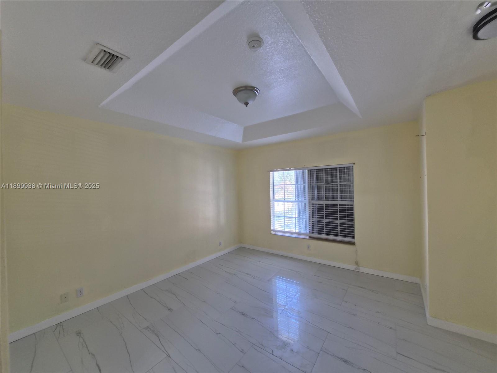 1209 Northwest 27th Avenue Pompano Beach, FL 33069 - Photo 19 of 22 an empty room with wooden floor and windows