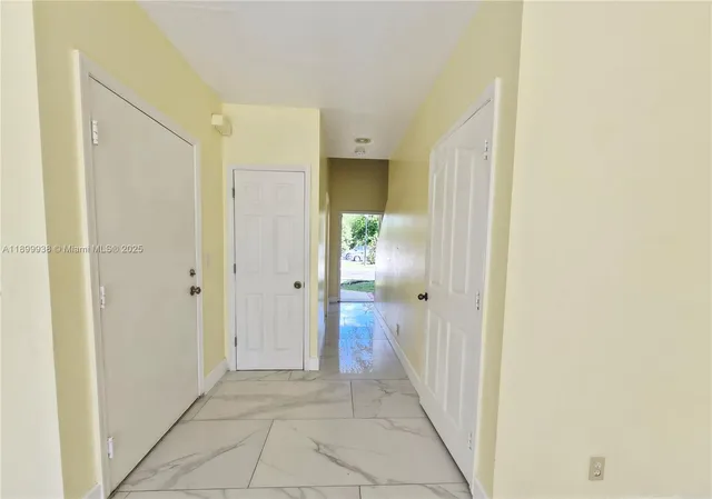 a view of a hallway with wooden floor and closet