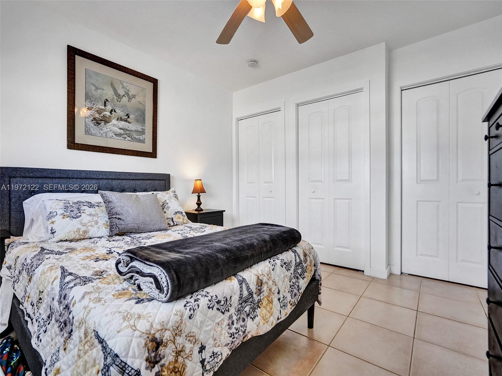 1815 North Surf Road, Unit 202 Hollywood, FL 33019 - Photo 12 of 32 a bedroom with a large bed and a chandelier