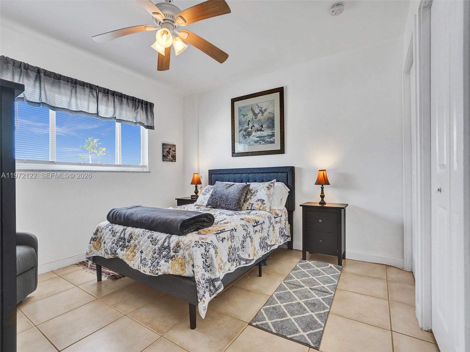 1815 North Surf Road, Unit 202 Hollywood, FL 33019 - Photo 13 of 32 a bedroom with a bed and a chandelier