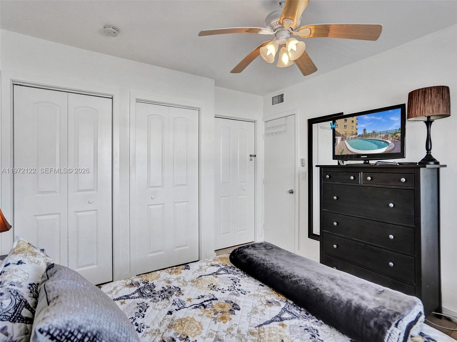 1815 North Surf Road, Unit 202 Hollywood, FL 33019 - Photo 14 of 32 a bedroom with a bed and a dresser