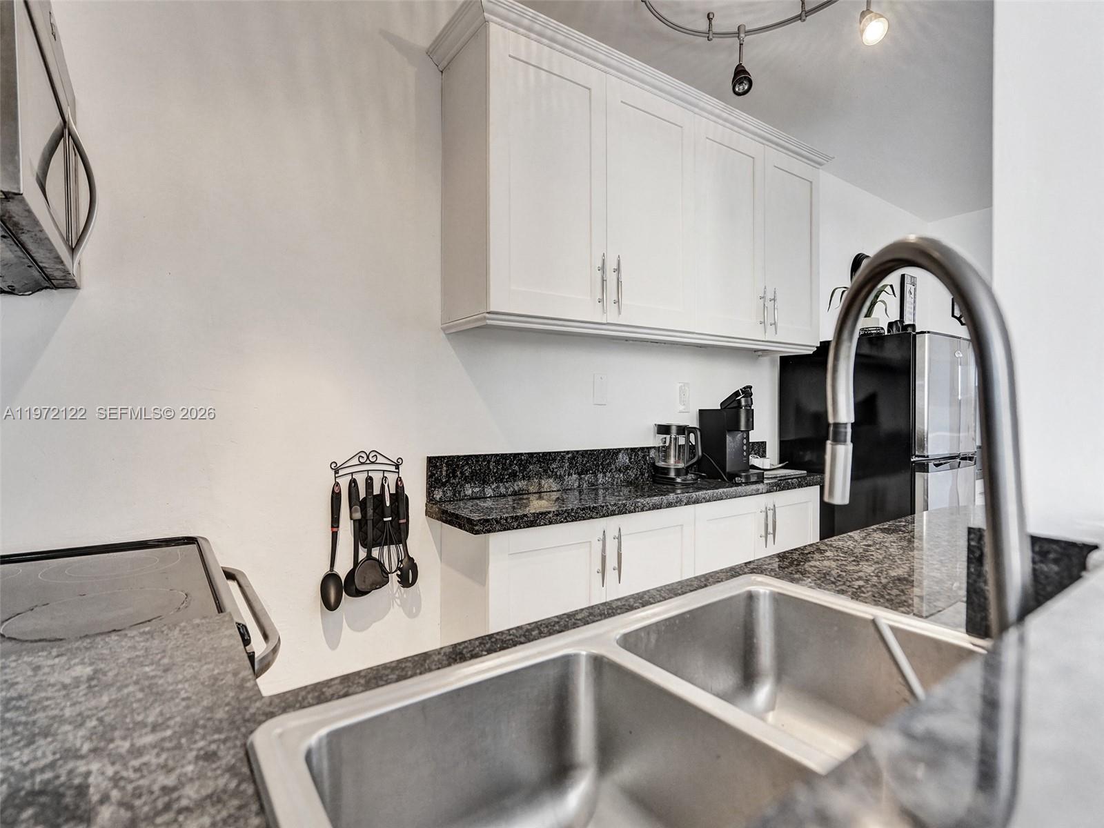 1815 North Surf Road, Unit 202 Hollywood, FL 33019 - Photo 22 of 32 a kitchen with a sink and cabinets