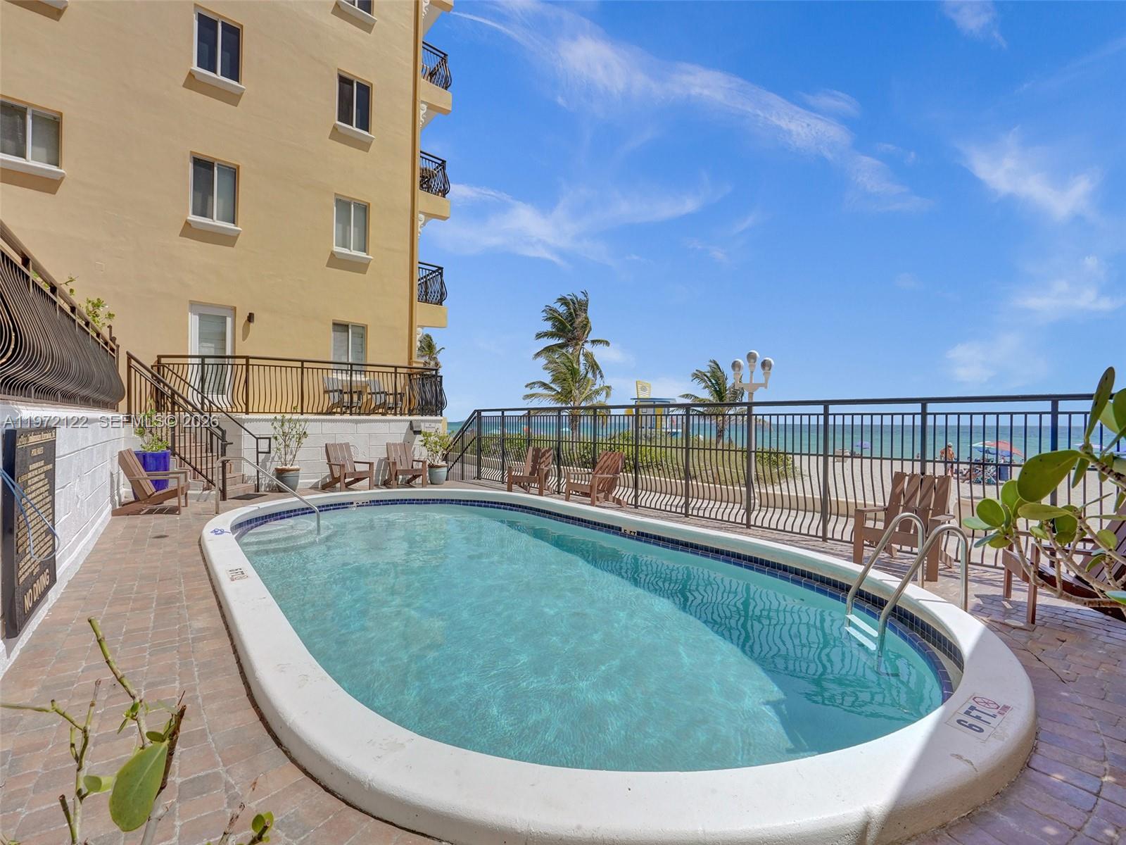 1815 North Surf Road, Unit 202 Hollywood, FL 33019 - Photo 29 of 32 a view of a swimming pool with a lounge chair