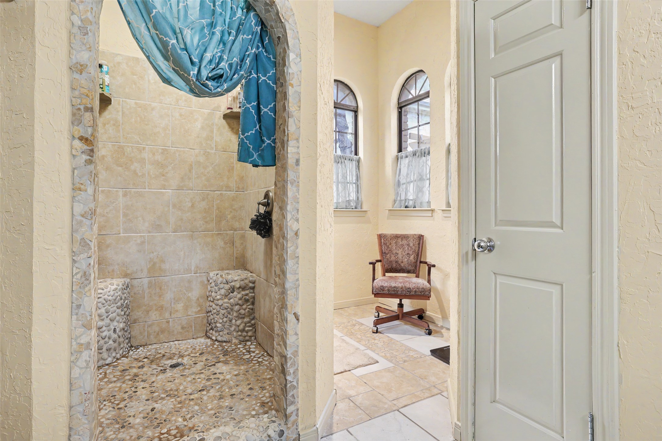 110 South Ridge Circle Georgetown, TX 78628 - Photo 18 of 37 Shower with pebble flooring and stone tile walls, featuring arched entry detailing