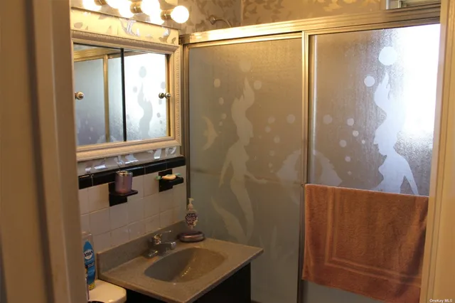 a bathroom with a sink a mirror and a shower