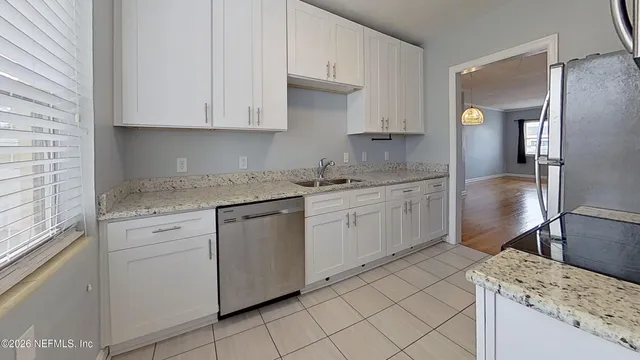 a kitchen with granite countertop white cabinets and white appliances