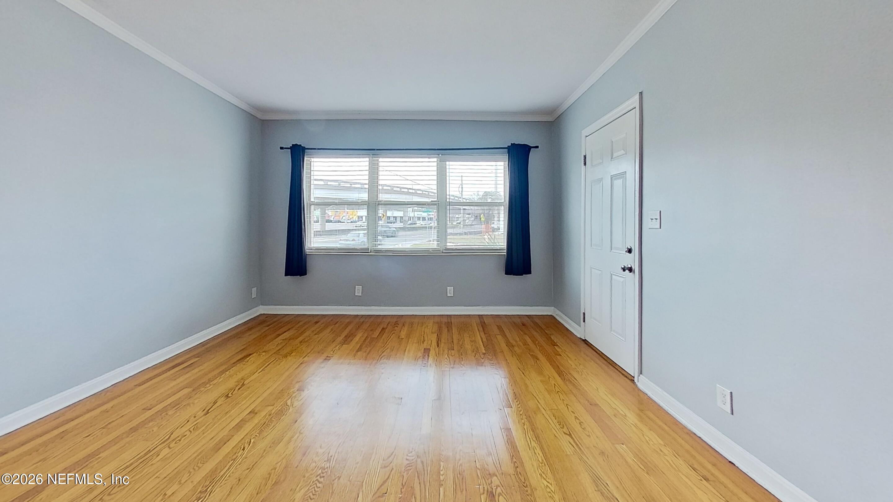 1551 Nicholson Road, Unit 2 Jacksonville, FL 32207 - Photo 4 of 19 an empty room with wooden floor and windows