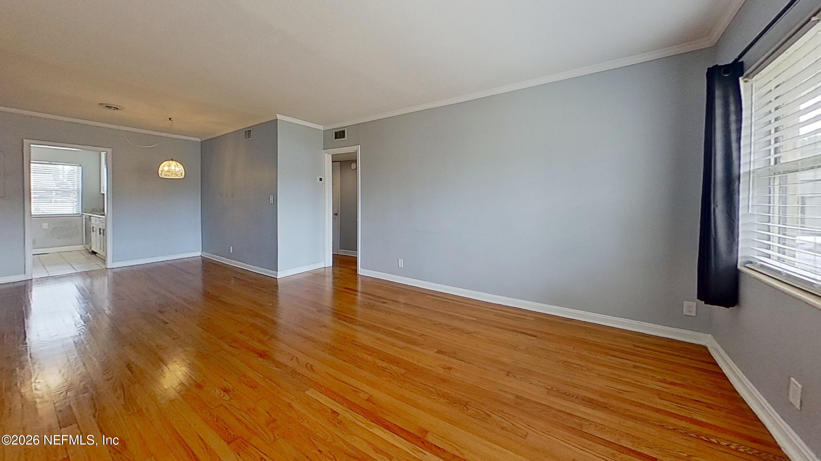 1551 Nicholson Road, Unit 2 Jacksonville, FL 32207 - Photo 6 of 19 a view of an empty room with wooden floor and a window