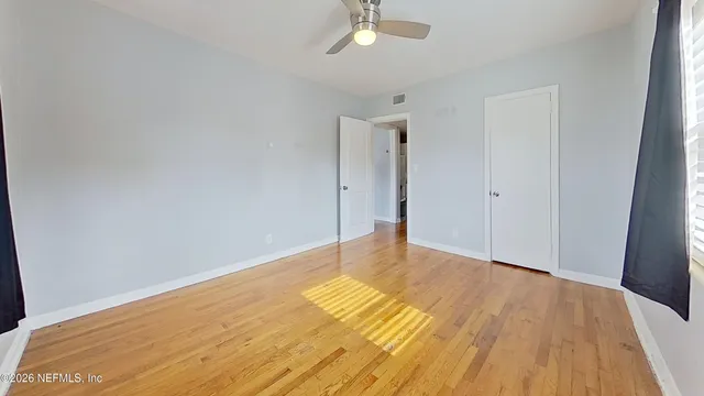 a view of an empty room with wooden floor