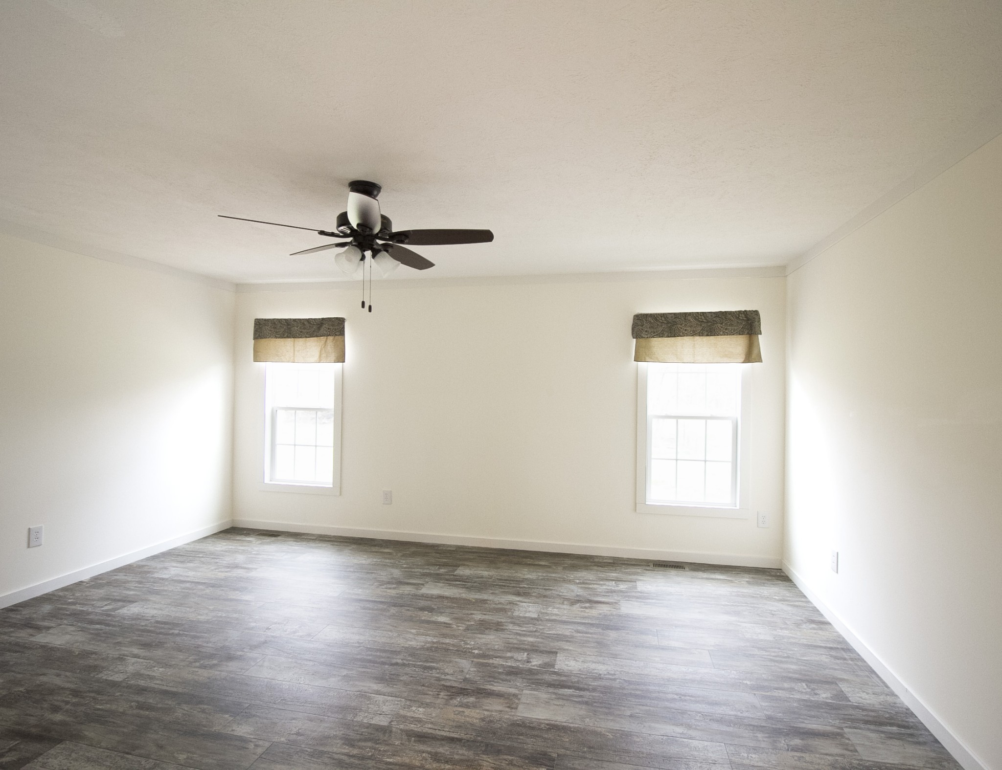2555 Liverpool Road Woodlawn, TN 37191 - Photo 9 of 21 an empty room with wooden floor chandelier fan and windows