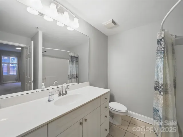 a bathroom with a sink a toilet a mirror and shower