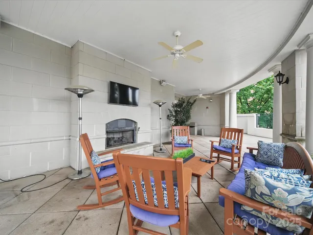 a living room with furniture a fireplace and a floor to ceiling window