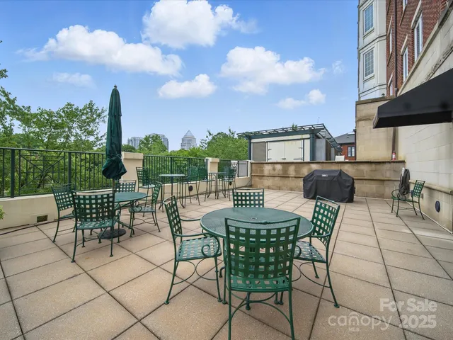a view of a terrace with furniture and city view