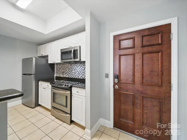 a kitchen with white cabinets and stainless steel appliances