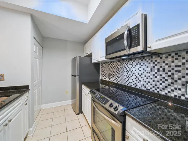 a kitchen with granite countertop a stove and a microwave