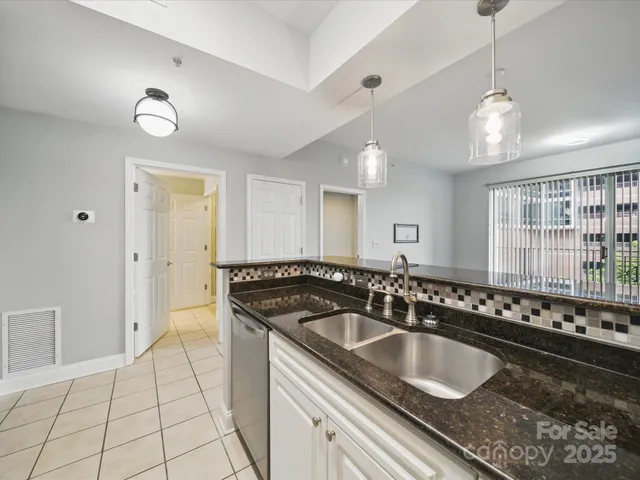 a kitchen with granite countertop a sink a stove and cabinets