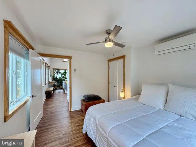 a living room with furniture large window and wooden floor