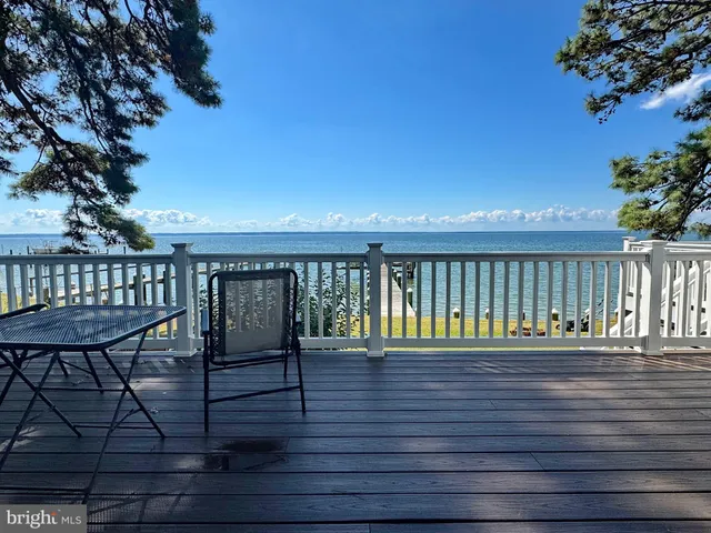 a view of a hallway with wooden floor and a mirror