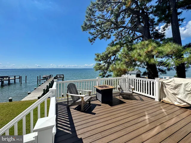 a living room with furniture a large window and wooden floor