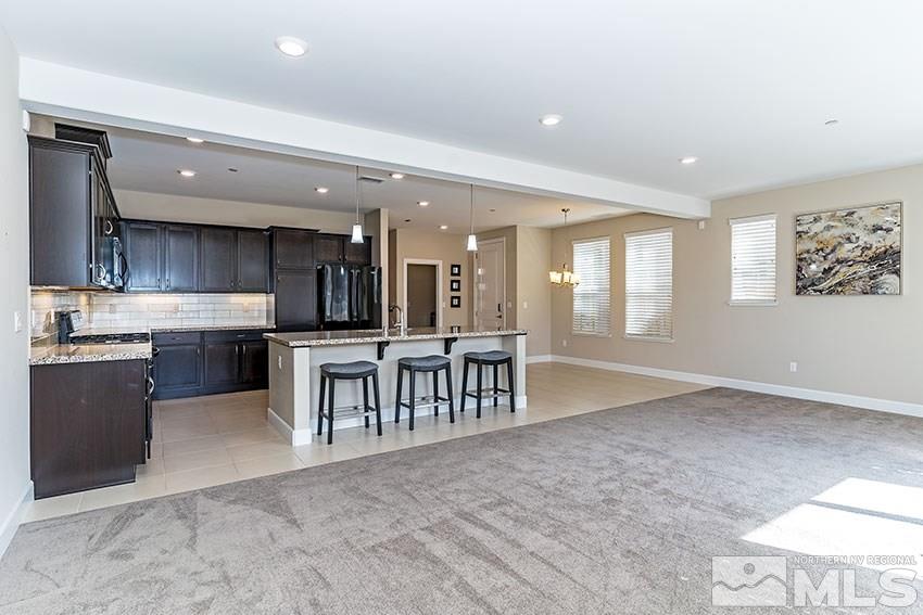 1991 Wind Ranch Road, Unit C Reno, NV 89521 - Photo 3 of 13 a open kitchen with stainless steel appliances granite countertop a stove and a sink