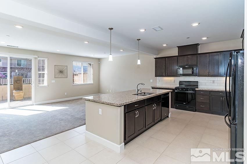 1991 Wind Ranch Road, Unit C Reno, NV 89521 - Photo 4 of 13 a kitchen with stainless steel appliances granite countertop a stove and a refrigerator