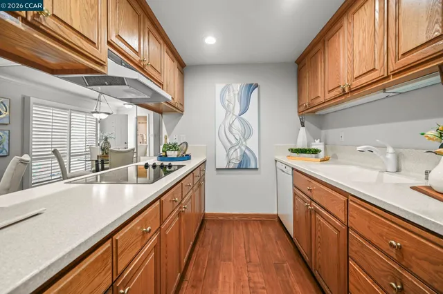 a kitchen with stainless steel appliances granite countertop a sink and wooden floors