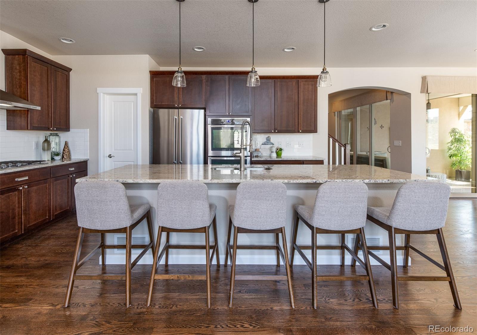 2589 South Kilmer Street Lakewood, CO 80228 - Photo 14 of 40 a kitchen with stainless steel appliances granite countertop a dining table chairs refrigerator and sink