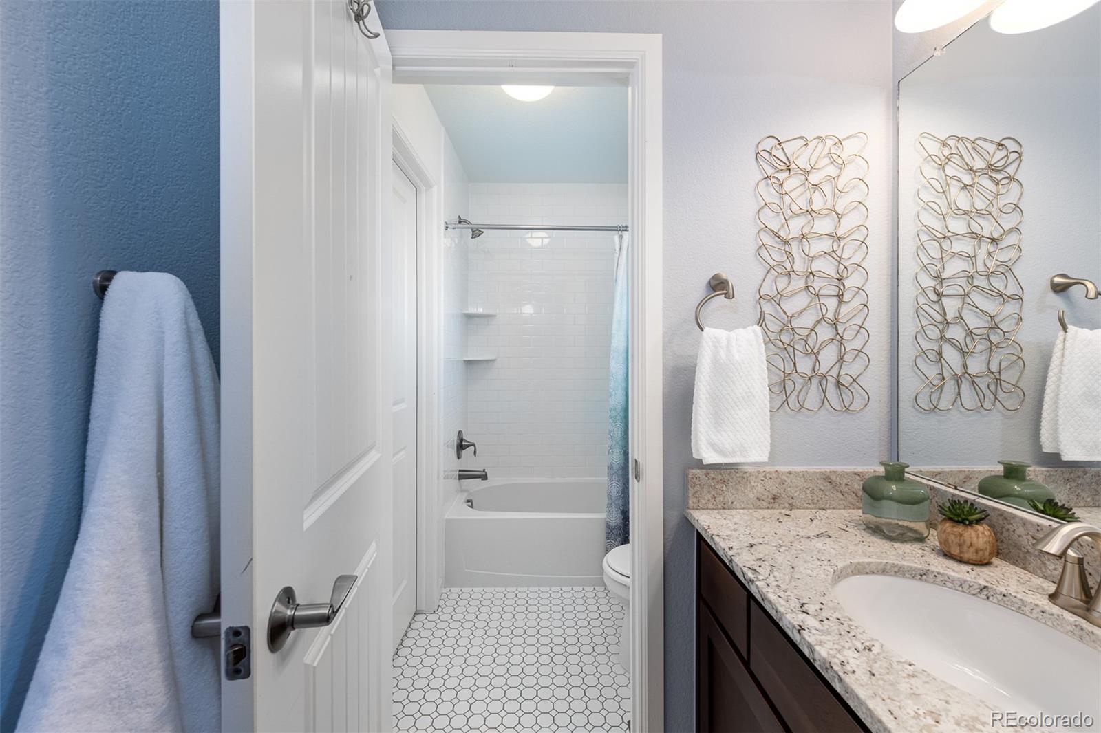 2589 South Kilmer Street Lakewood, CO 80228 - Photo 27 of 40 a bathroom with a granite countertop sink a toilet and shower