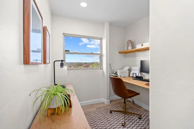 a large white kitchen with a large window a sink and stainless steel appliances