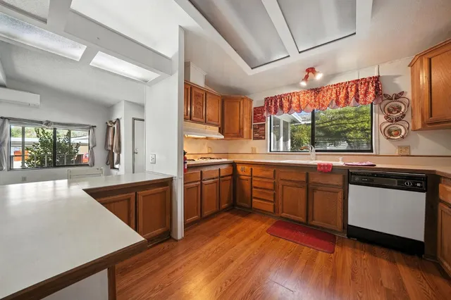 a kitchen with stainless steel appliances granite countertop a refrigerator a microwave oven cabinets and wooden floor