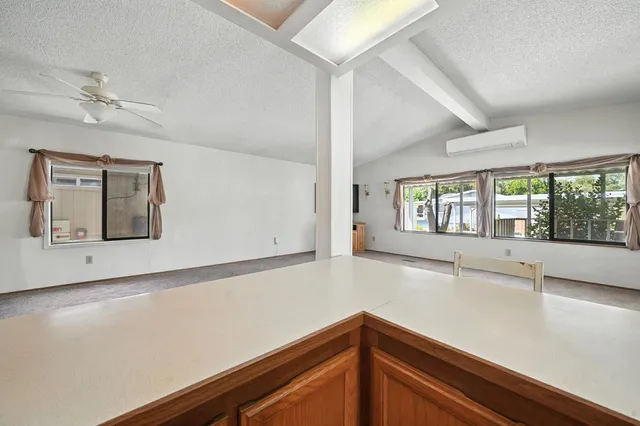 a view of an empty room with a flat screen tv and windows