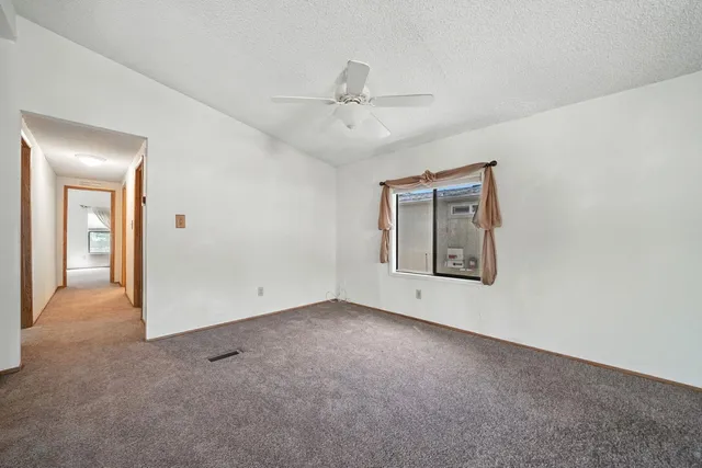 a view of empty room with windows and bathroom view