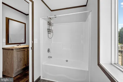 a bathroom with a bathtub a shower a sink and a window