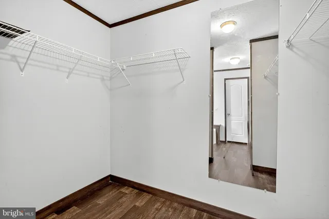 a view of walk in closet with empty racks