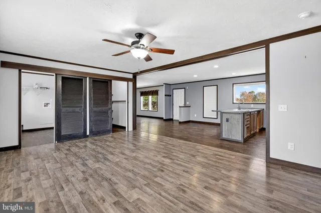 a view of a livingroom with wooden floor and ceiling fan