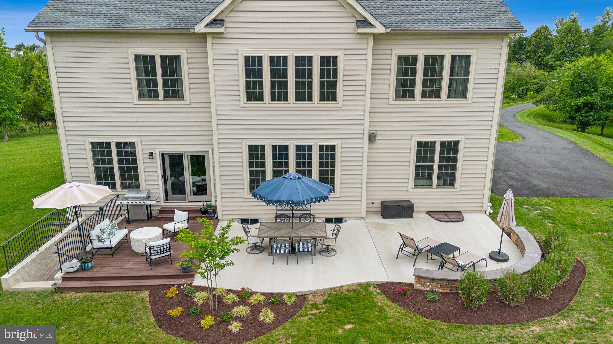 237 Barberry Lane Laytonsville, MD 20882 - Photo 13 of 70 a view of a backyard with table and chairs potted plants and a barbeque