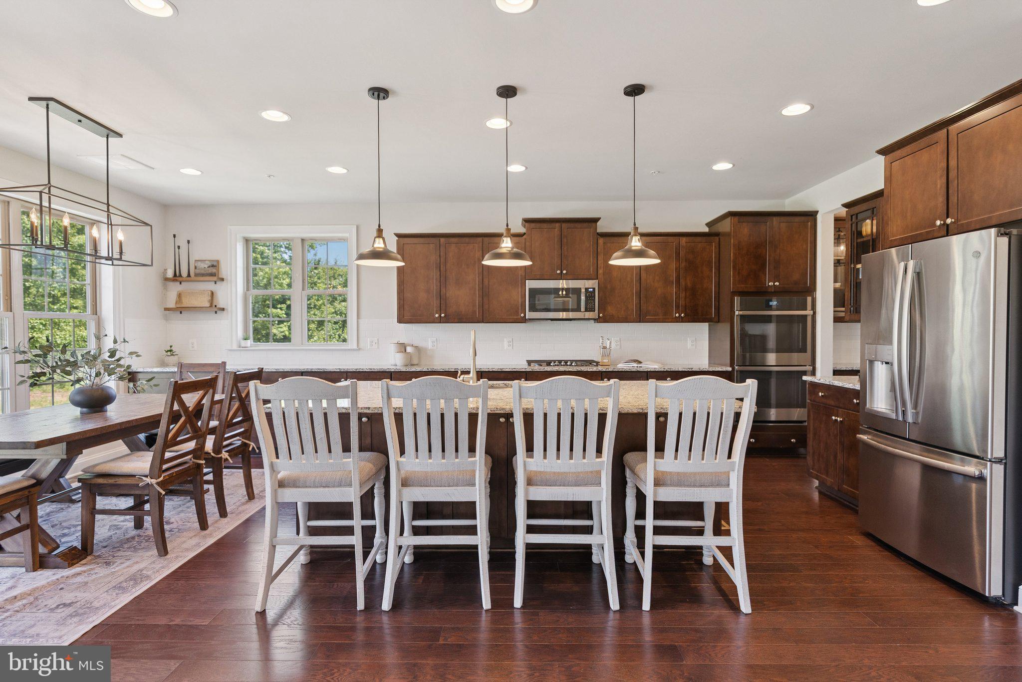 237 Barberry Lane Laytonsville, MD 20882 - Photo 9 of 70 a kitchen with stainless steel appliances granite countertop a kitchen island a table and chairs