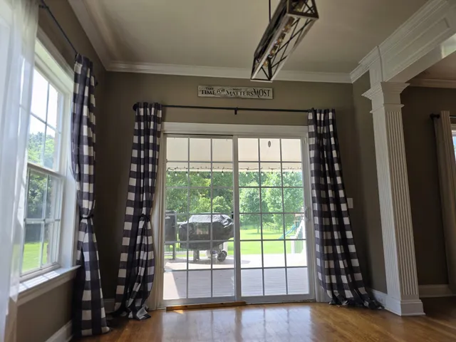 an empty room with wooden floor and a kitchen