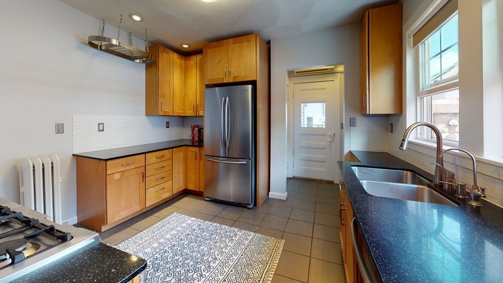 54 Chester Road, Unit 1 Belmont, MA 02478 - Photo 5 of 11 a kitchen with stainless steel appliances granite countertop a refrigerator a sink and a stove