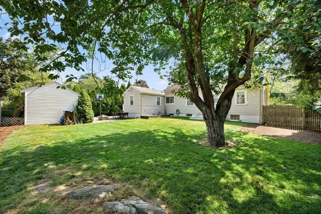 a view of a house with backyard and sitting area