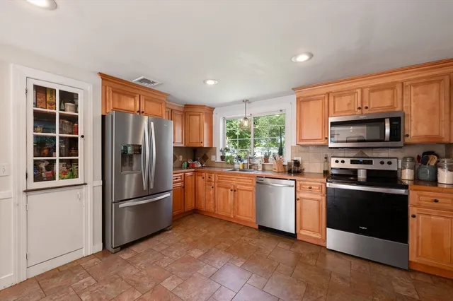 a kitchen with stainless steel appliances granite countertop a refrigerator stove and microwave
