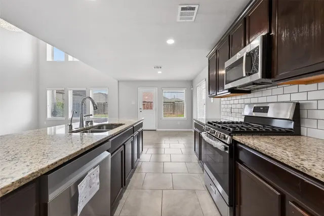 a kitchen with stainless steel appliances granite countertop a stove and a sink