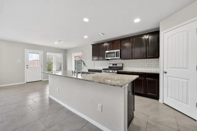 a kitchen with stainless steel appliances granite countertop a stove sink and cabinets