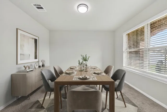 a view of a dining room with furniture and window