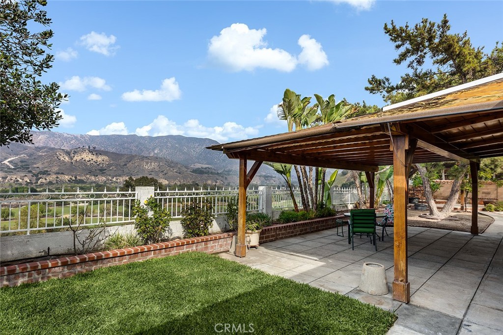9071 Riderwood Drive Sunland, CA 91040 - Photo 41 of 46 a view of a patio with table and chairs under an umbrella with a garden