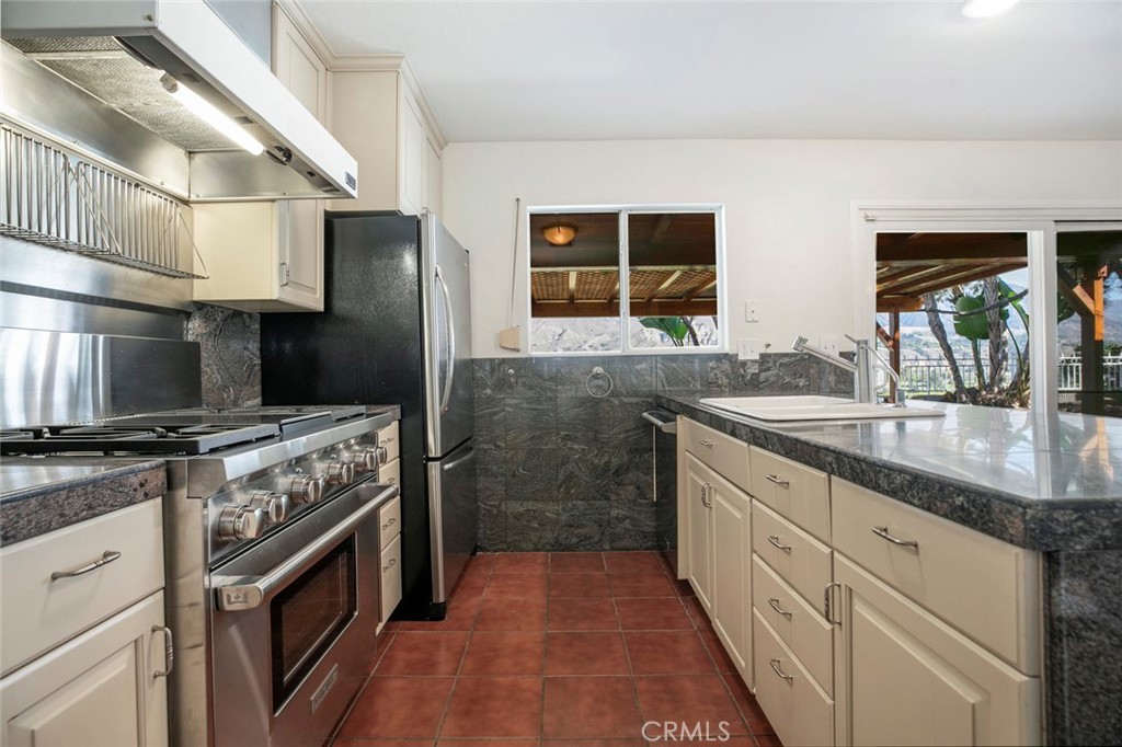 9071 Riderwood Drive Sunland, CA 91040 - Photo 9 of 46 a kitchen with granite countertop a sink stove and cabinets