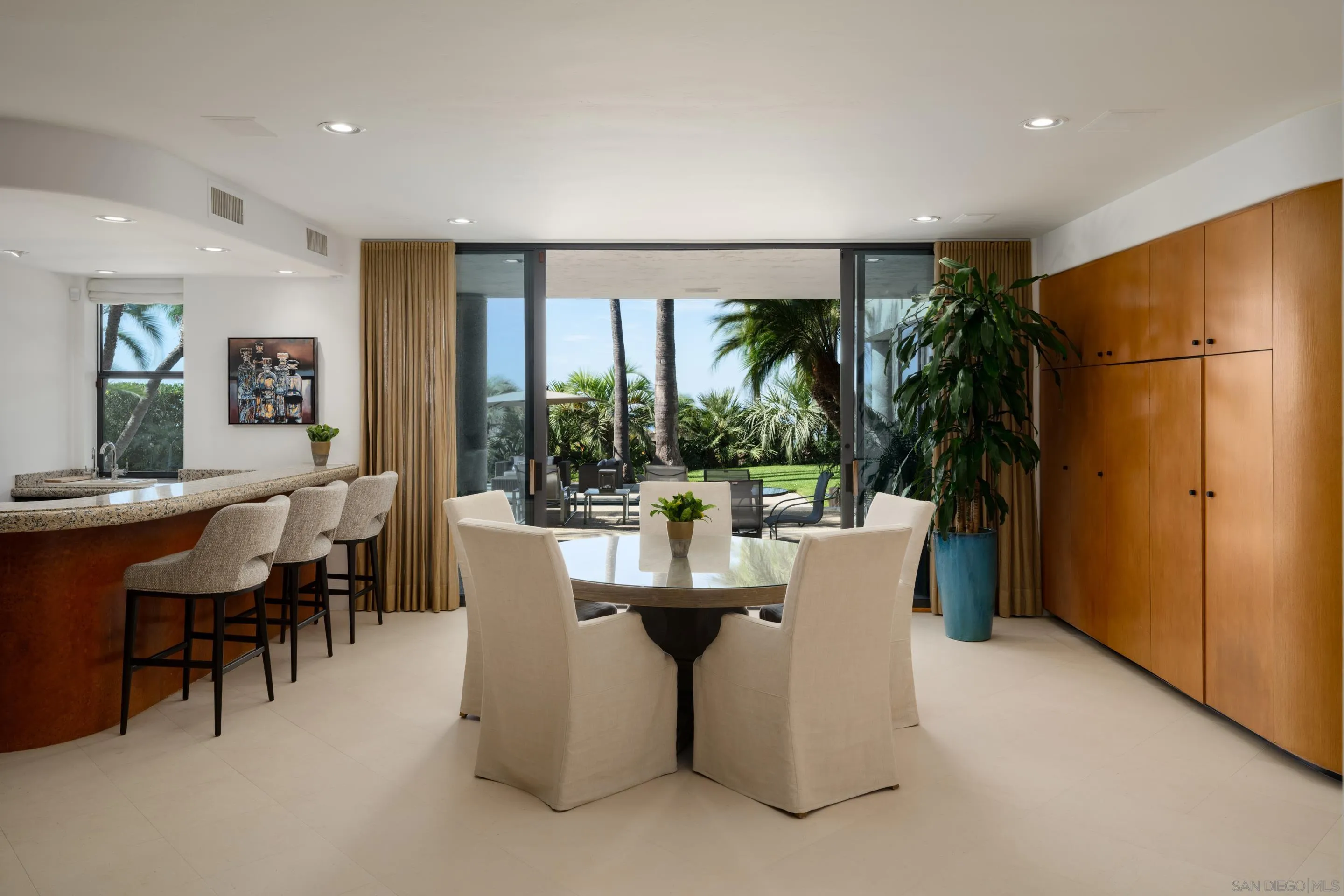 8633 Ruette Monte Carlo La Jolla, CA 92037 - Photo 37 of 48 a dining room with furniture a large window and a refrigerator