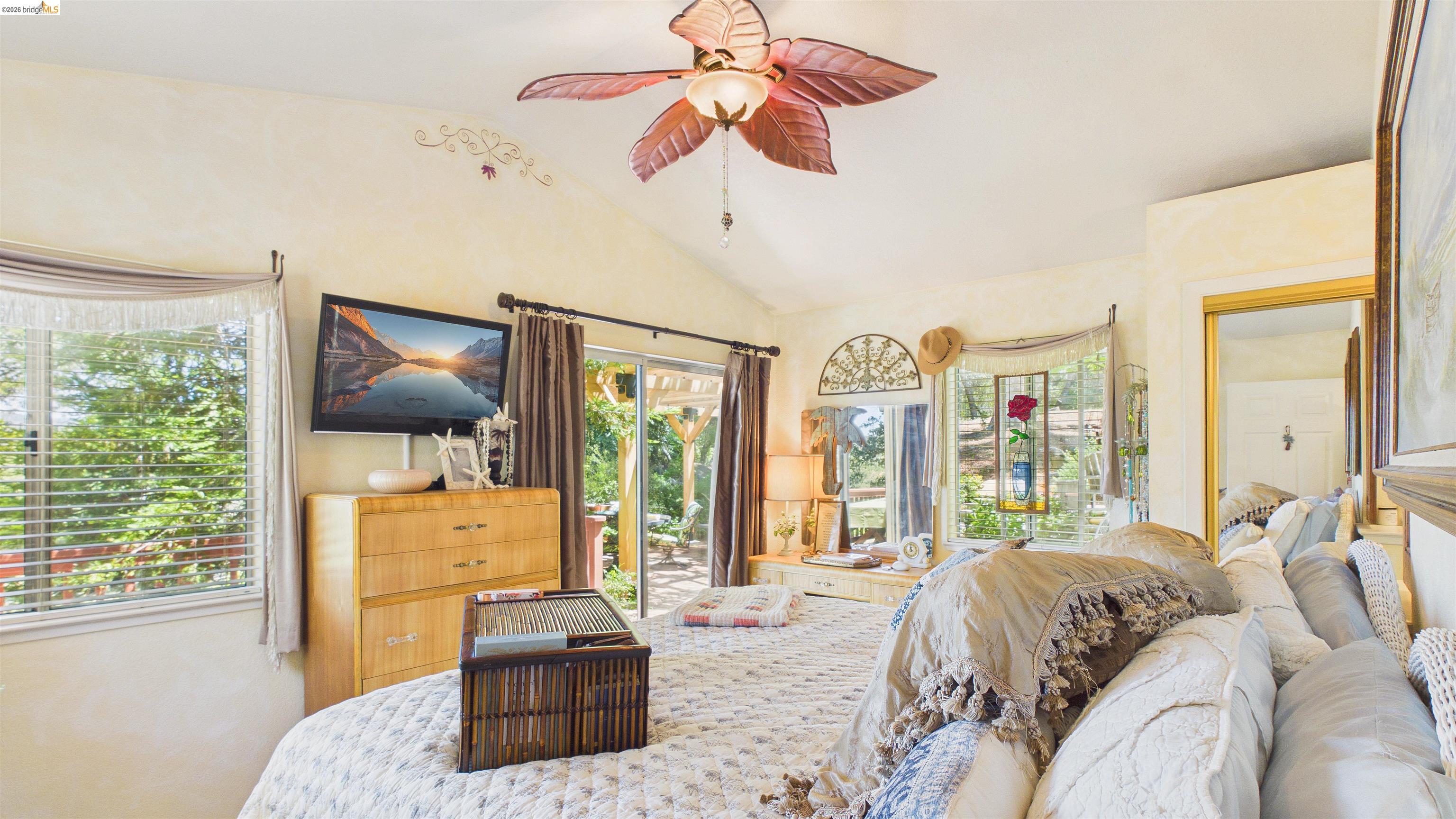 18102 Mt Eaton Road Tuolumne, CA 95379 - Photo 13 of 44 Vaulted ceilings with a ceiling fan, sliding glass doors to an exterior patio, multiple windows, and a built-in mirror