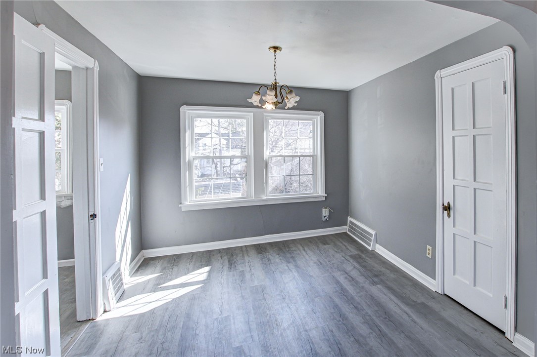 3423 Westbury Road Cleveland, OH 44120 - Photo 28 of 38 Empty room featuring a notable chandelier and dark wood-type flooring