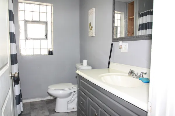 a bathroom with a sink toilet and window